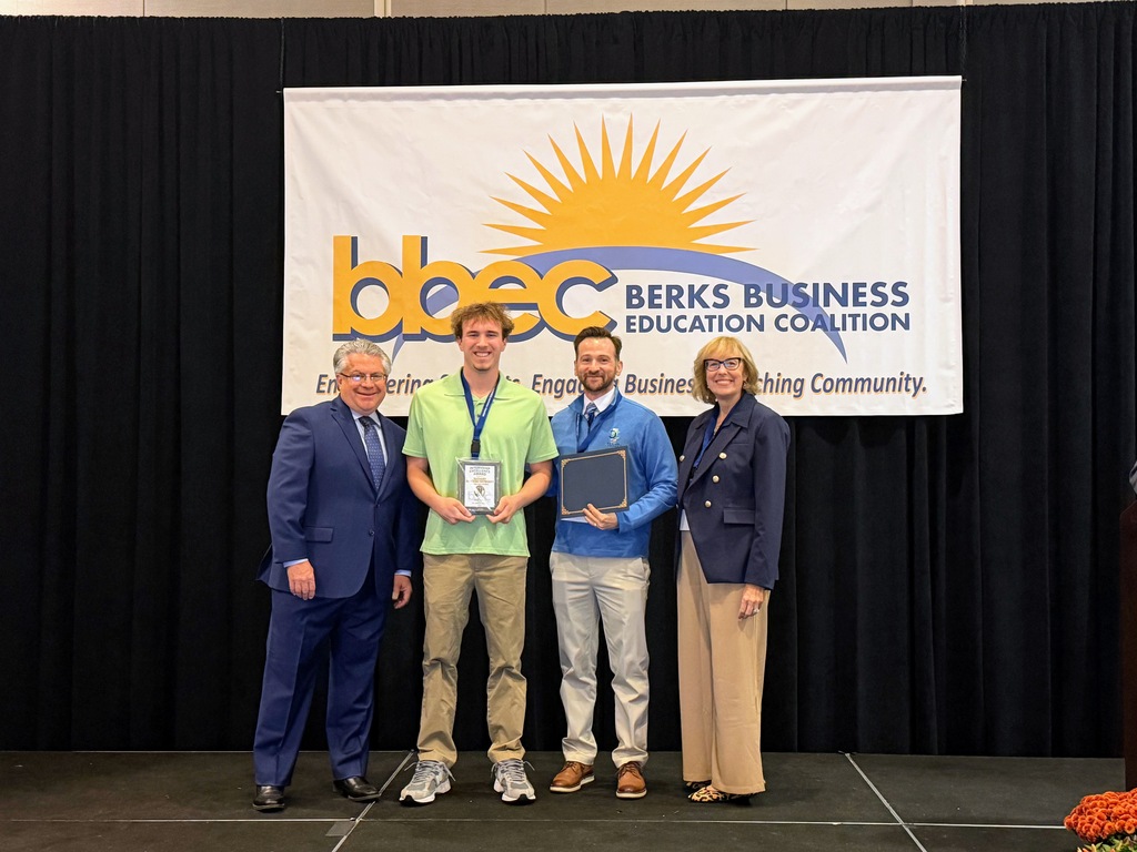 student standing with professsionals in front of a bbec sign