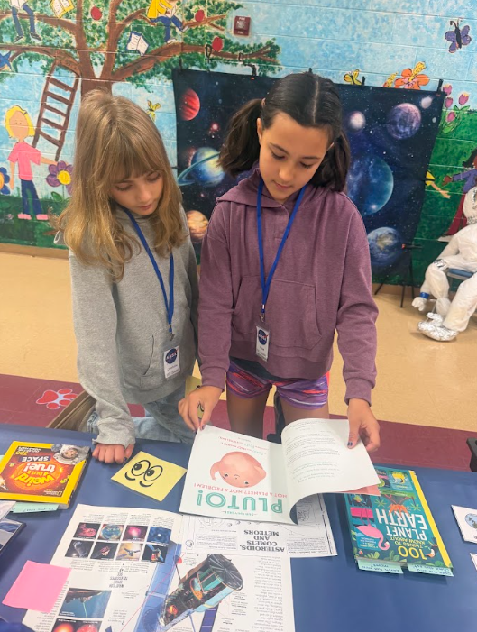 students looking at books at cafeteria table