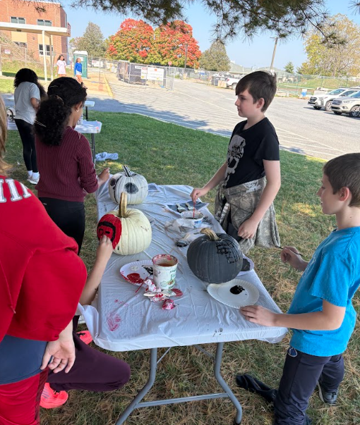 students painting pumpkins