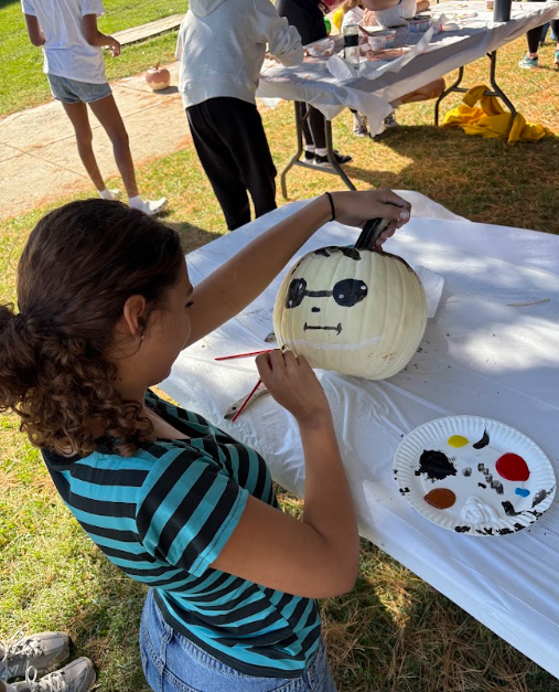 student painting a pumpkin