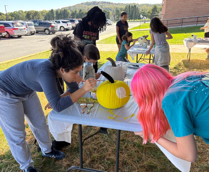 students painting pumpkins