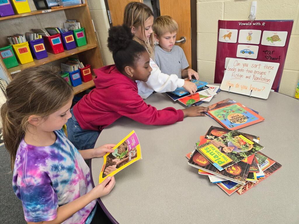 students look at magazine at table