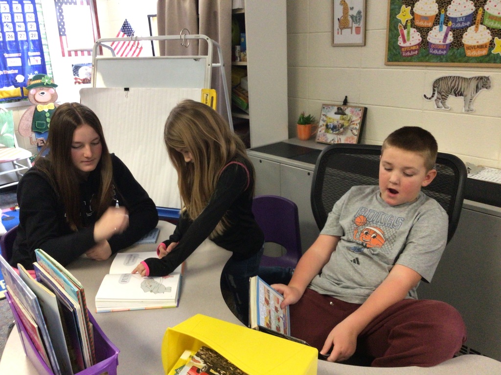 2 girls and a boy reading