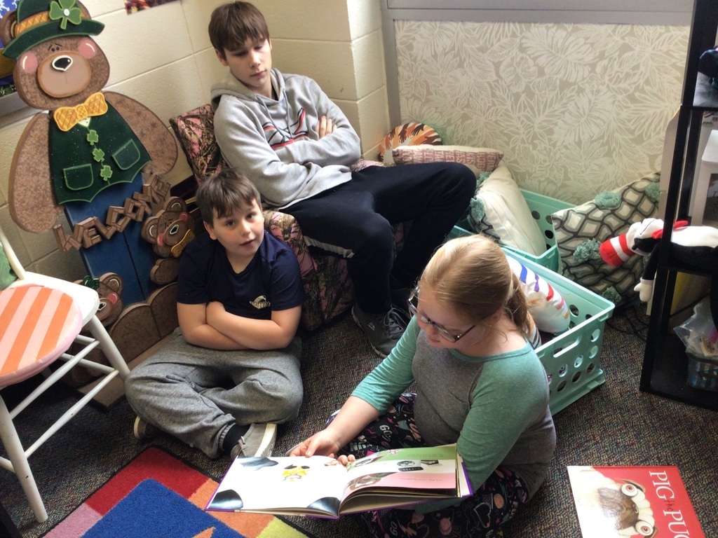 2 boys and a girl reading a book