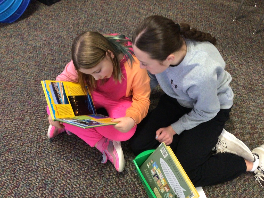 2 girls reading a book