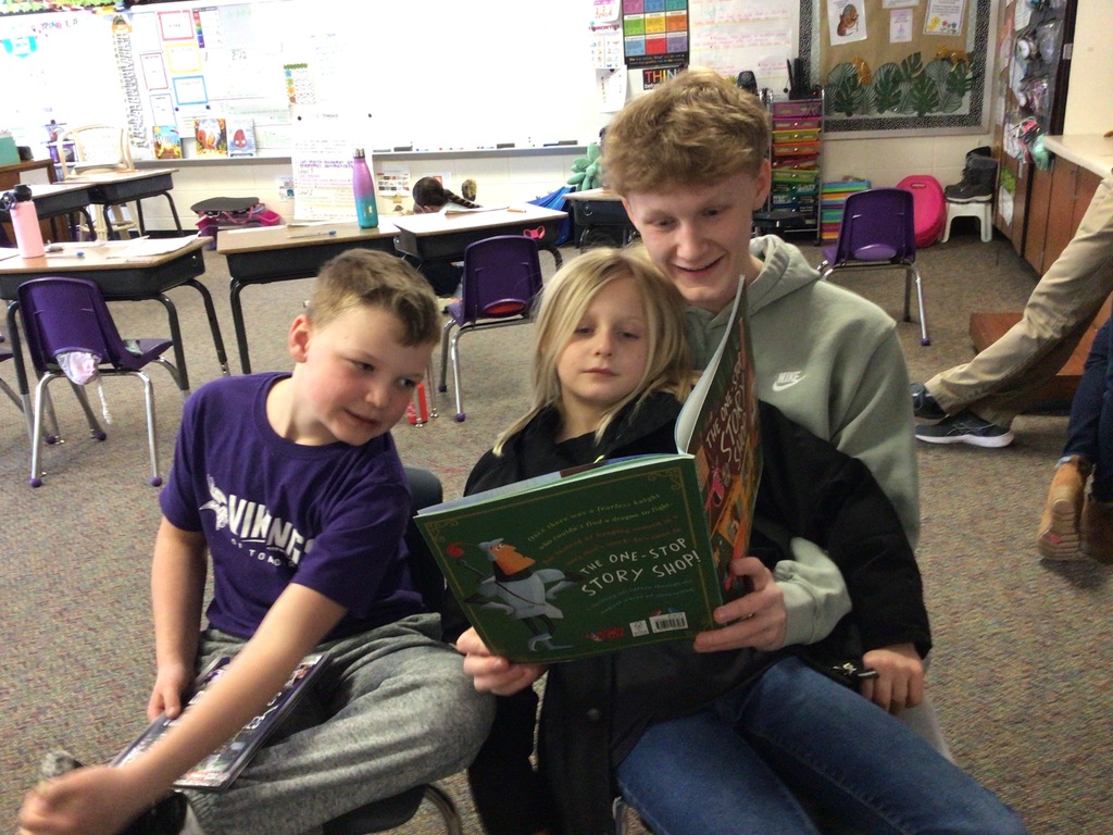 2 boys and a girl reading a book