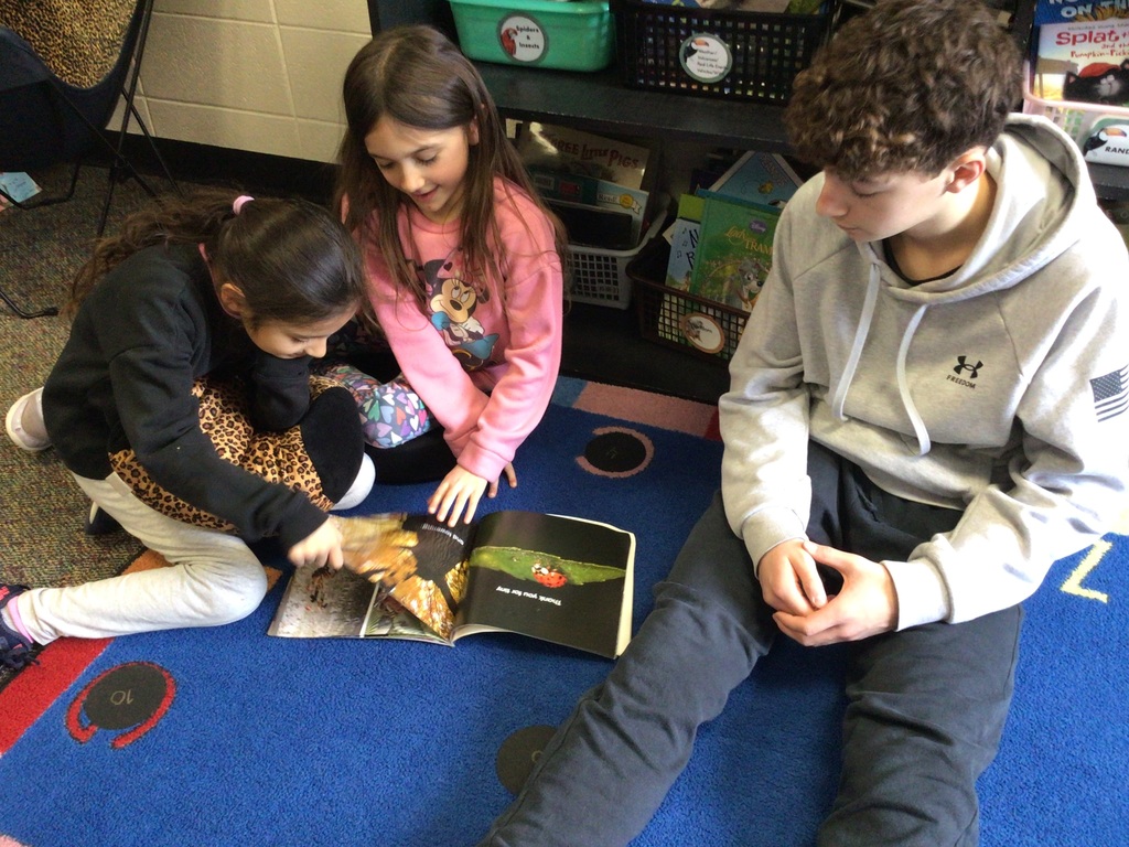 2 girls and a boy reading