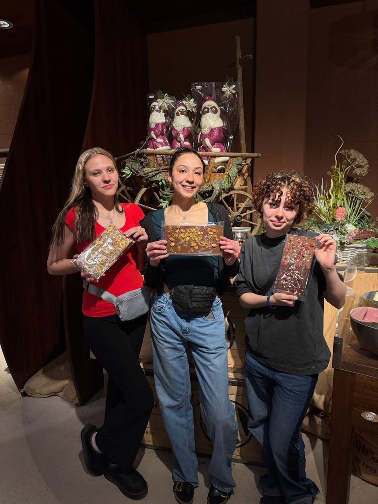 three students holding chocolate