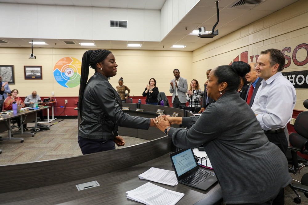 Student shakes a hand of a new BOE member