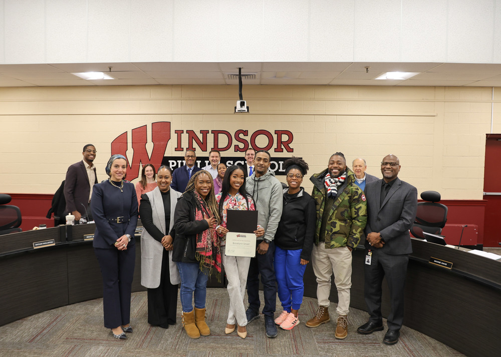 Student Representative and her family are surrounded by BOE members