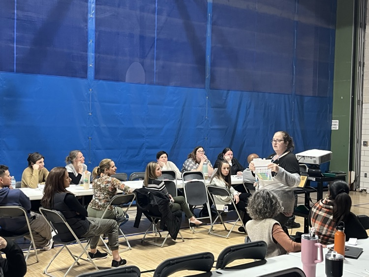 Mrs. G presenting to staff in gym at OE