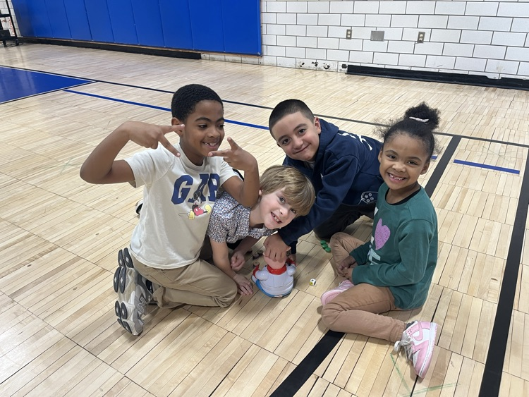 students posing while playing a board game in the gym
