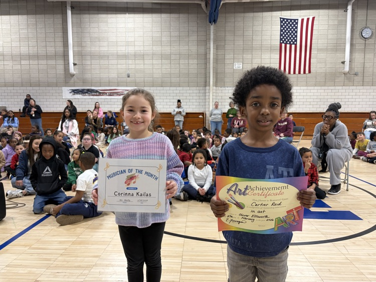 two students holding artist and music certificate of the month 