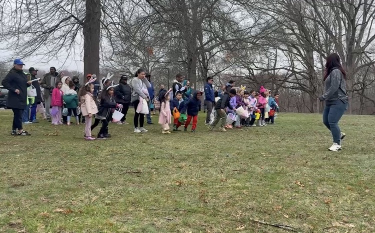 students holding their baskets about to participate in egg hunt outside  