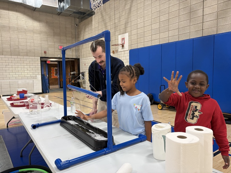 student putting their hand through a bubble at science centers assembly in gym