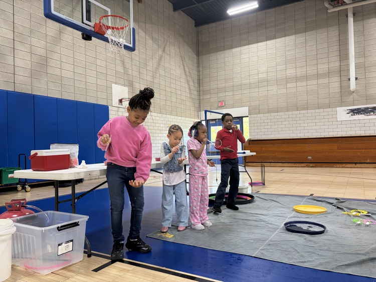 student participating with bubbles at science centers assembly in gym
