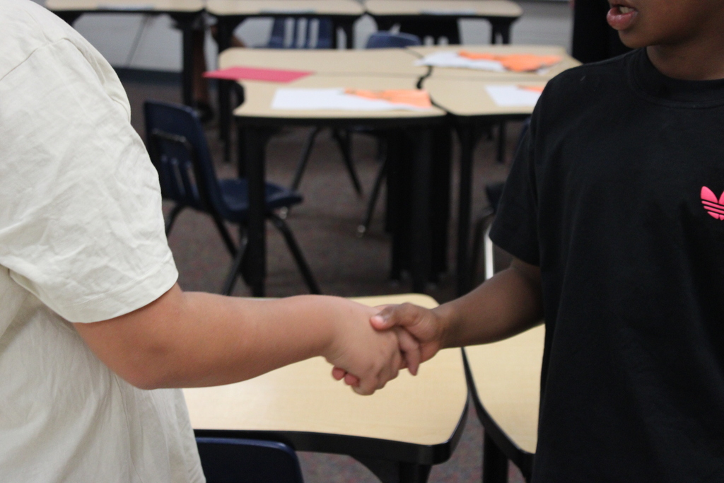 Two students shaking hands