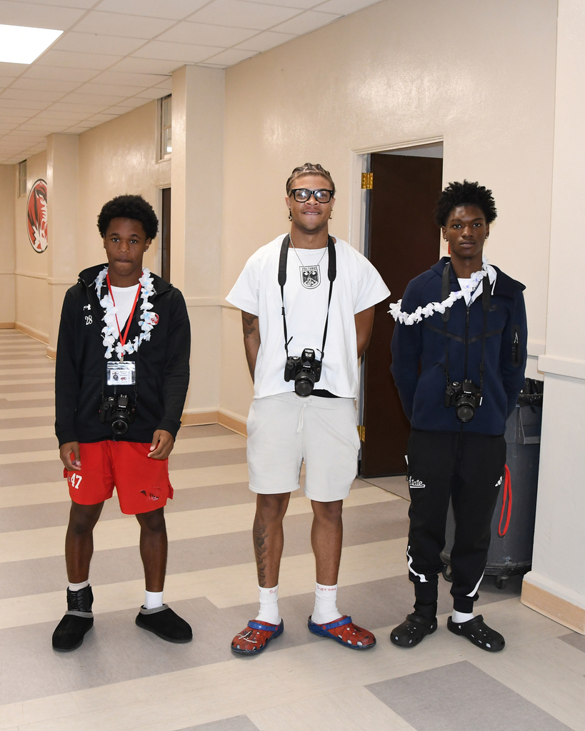 three boys in a hall with cameras