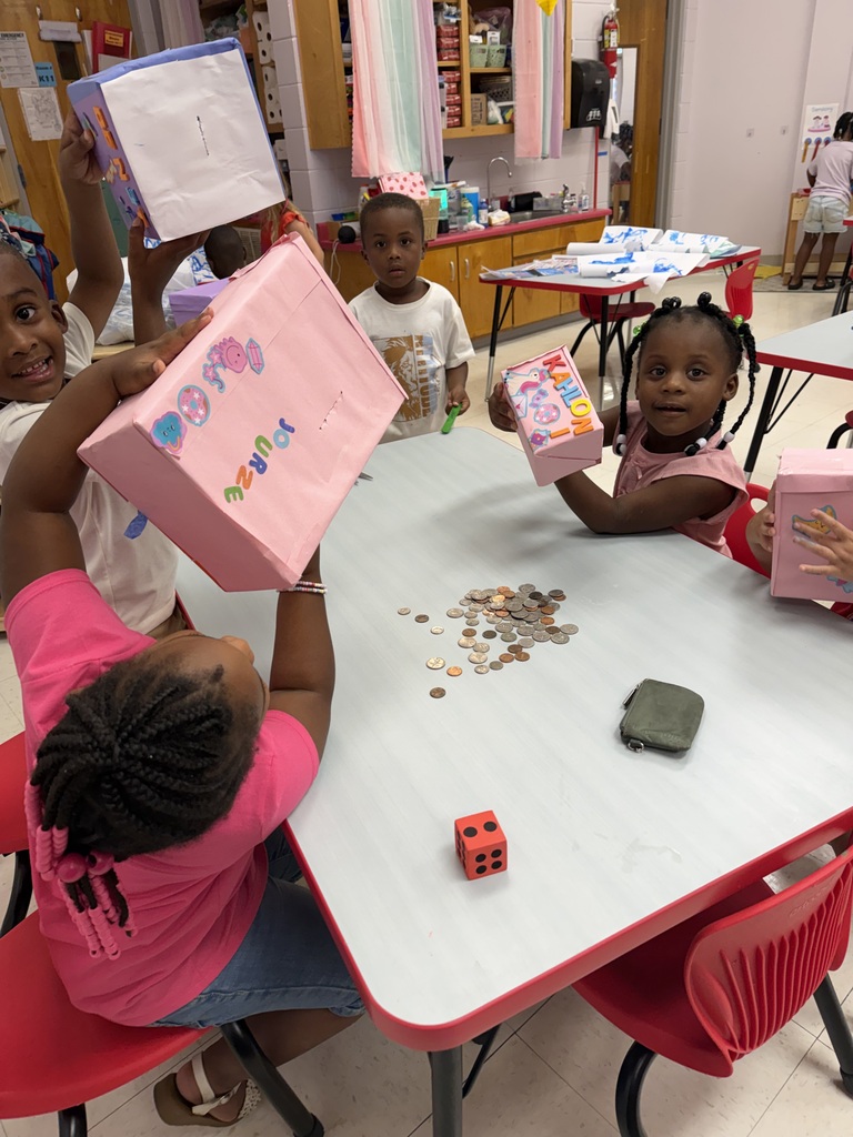 Four children seated around a table, engaged in counting and sorting coins from a bag.