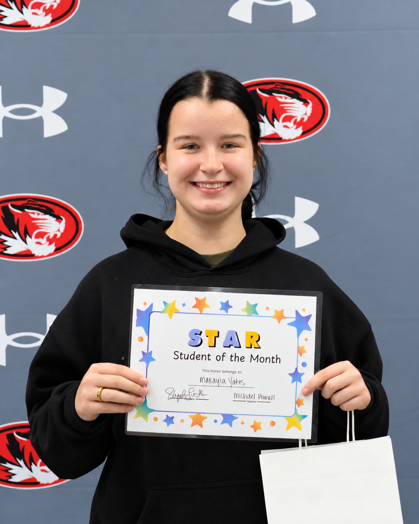 Woman wearing black hoodie holds a certificate with "STAR Student of the Month" on it.