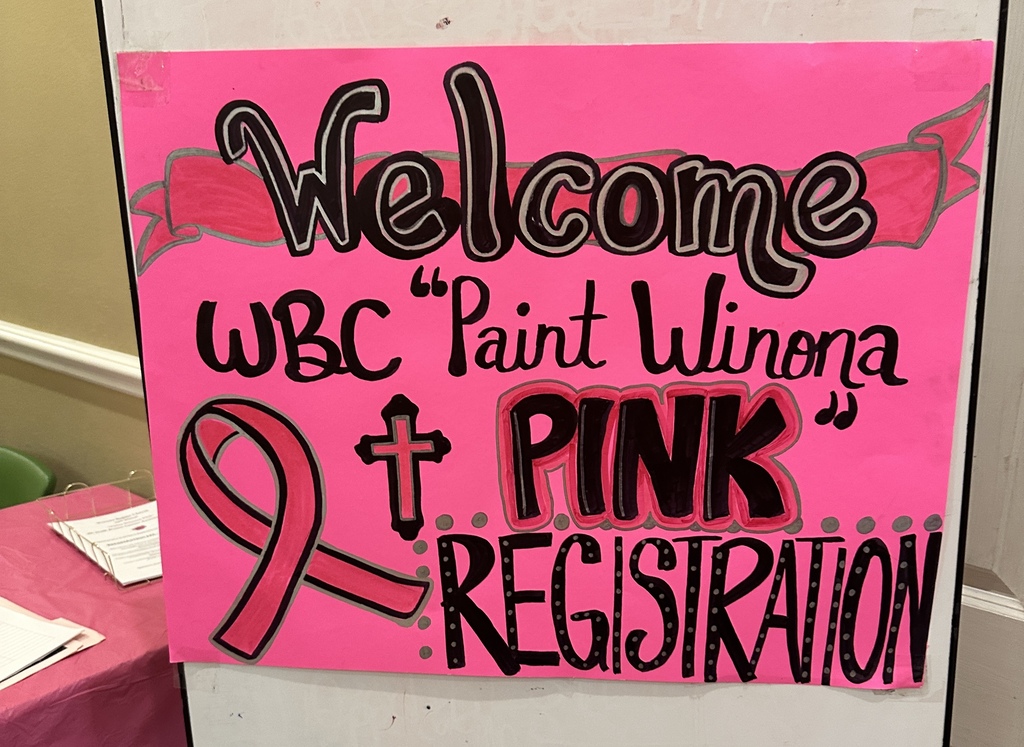 Pink sign with white letters reading "Welcome WBC 'Paint Winona + PINK' REGISTRATION" and a pink ribbon.