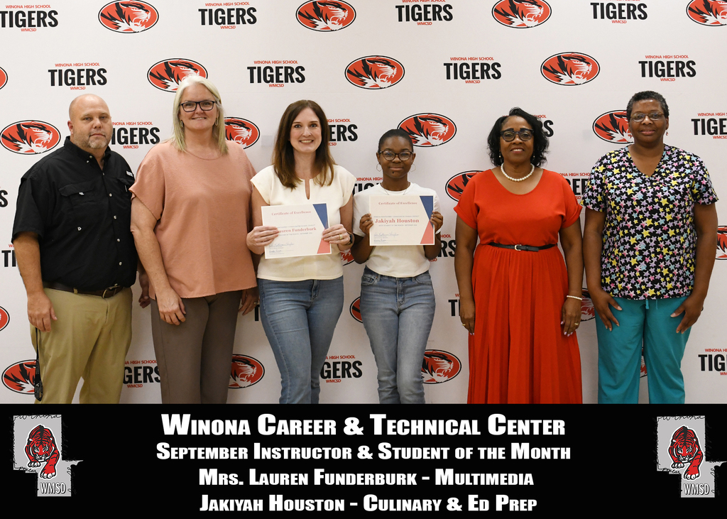 A group of six people stands before a wall with Tiger logos. They hold certificates. Text reads "Winona Career & Technical Center".