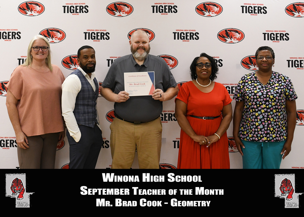 Five adults stand in front of a wall with the text "Winona High School" and "September Teacher of the Month."