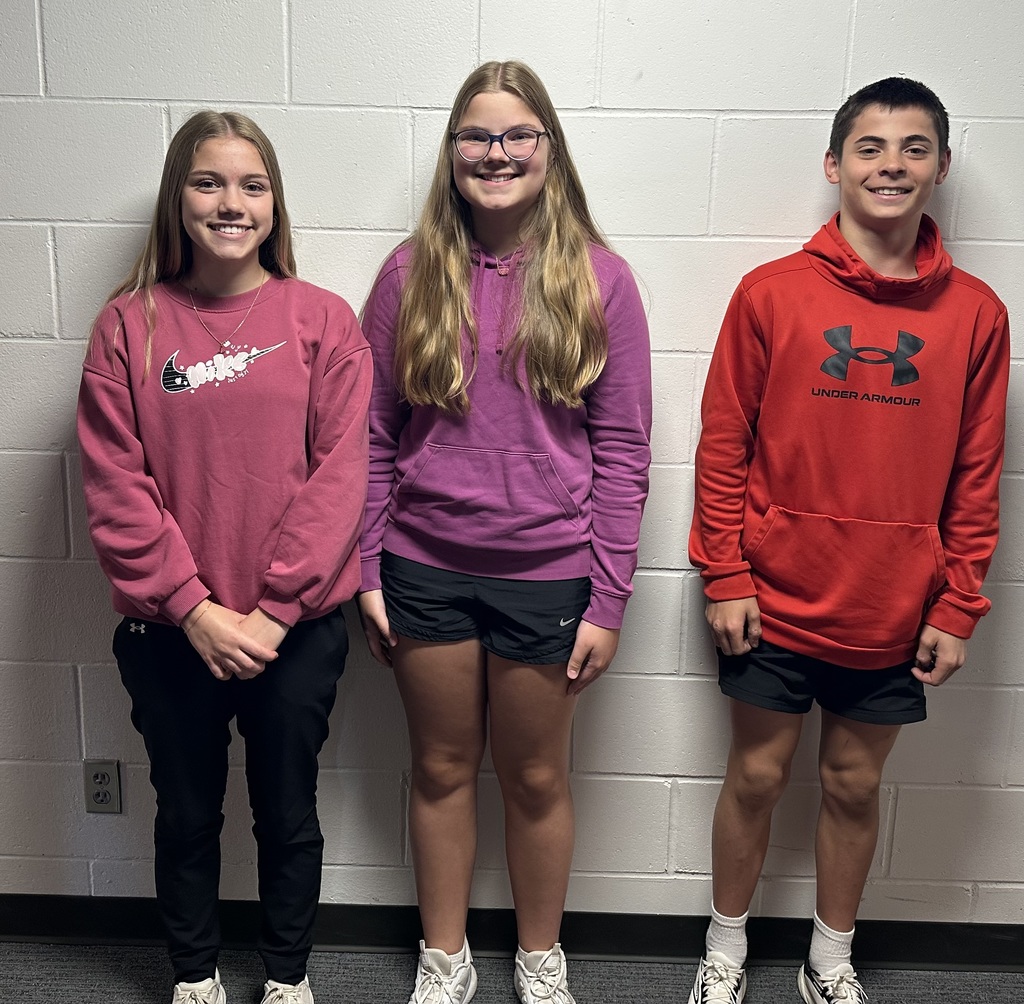 From left to right student smiling in front of a blank white wall: Alayna Carlson, Tate Petersen, and Paxton Grothe