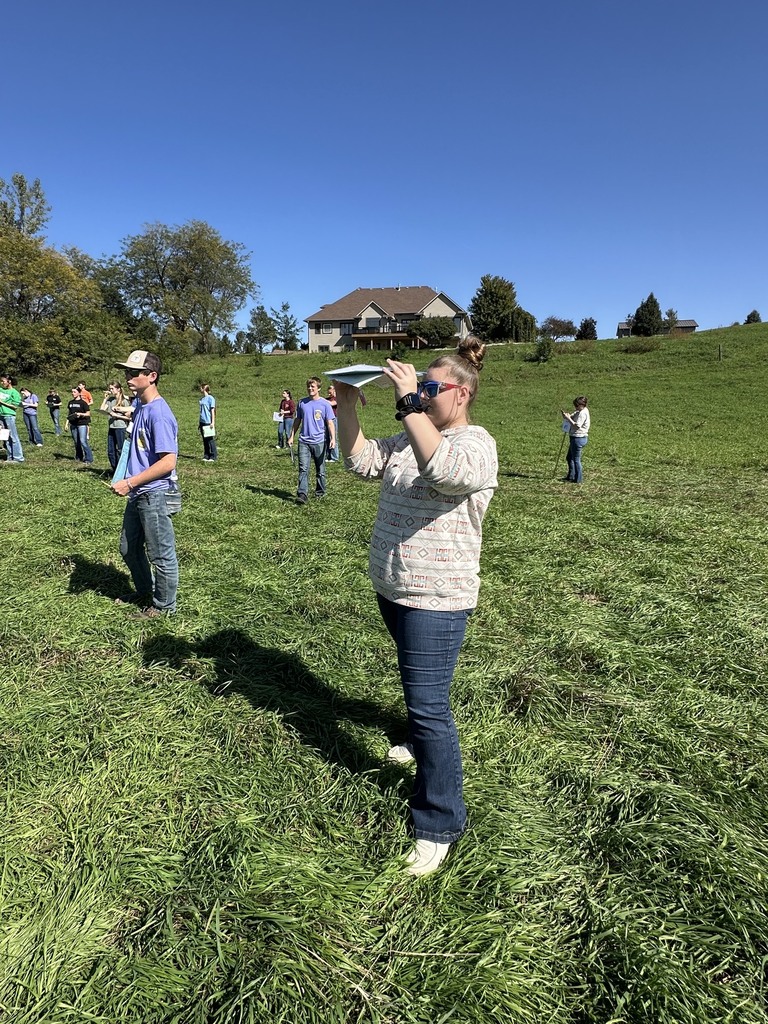 Student standing in a field studying Land Judging papers