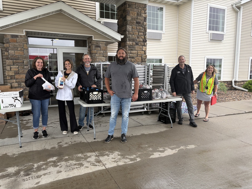 Volunteers pose with packaged meals for distribution
