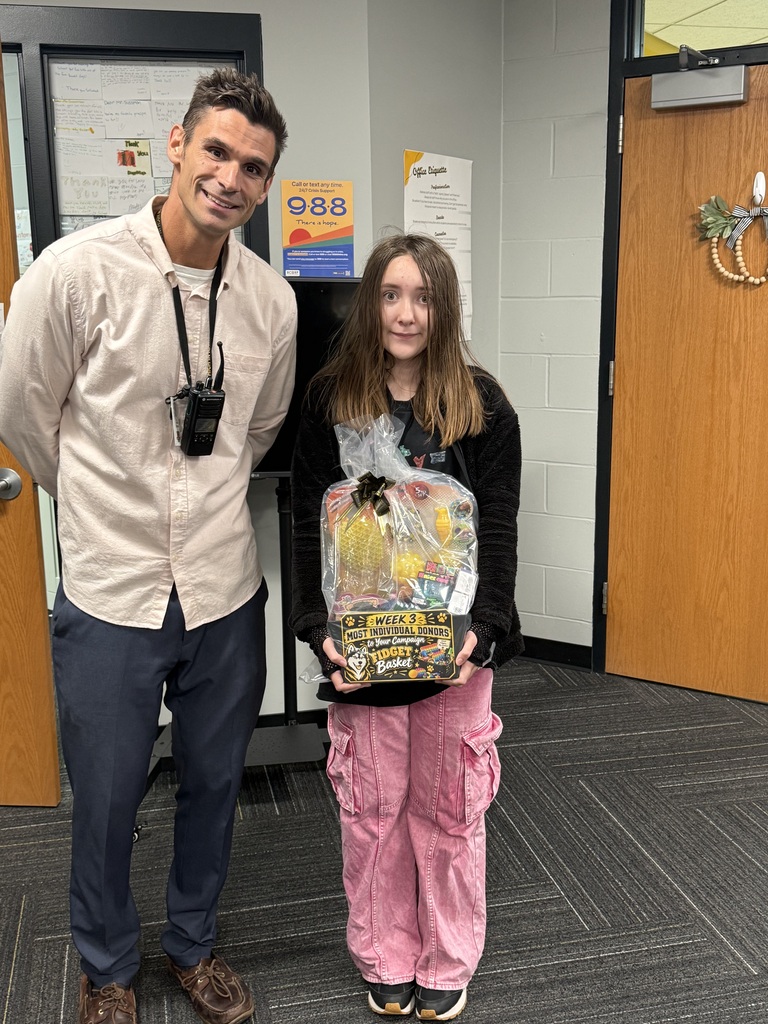 A man and girl standing in a hallway, smiling and posing for a photo.