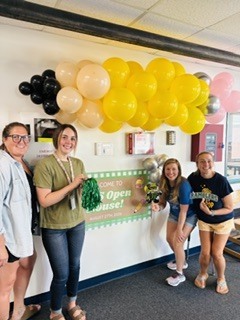 Picture of staff in front of the welcome to open house sign.