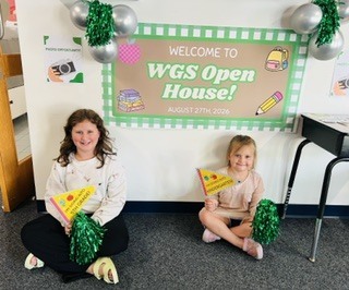 Picture of staff and students in front of welcome to open house sign