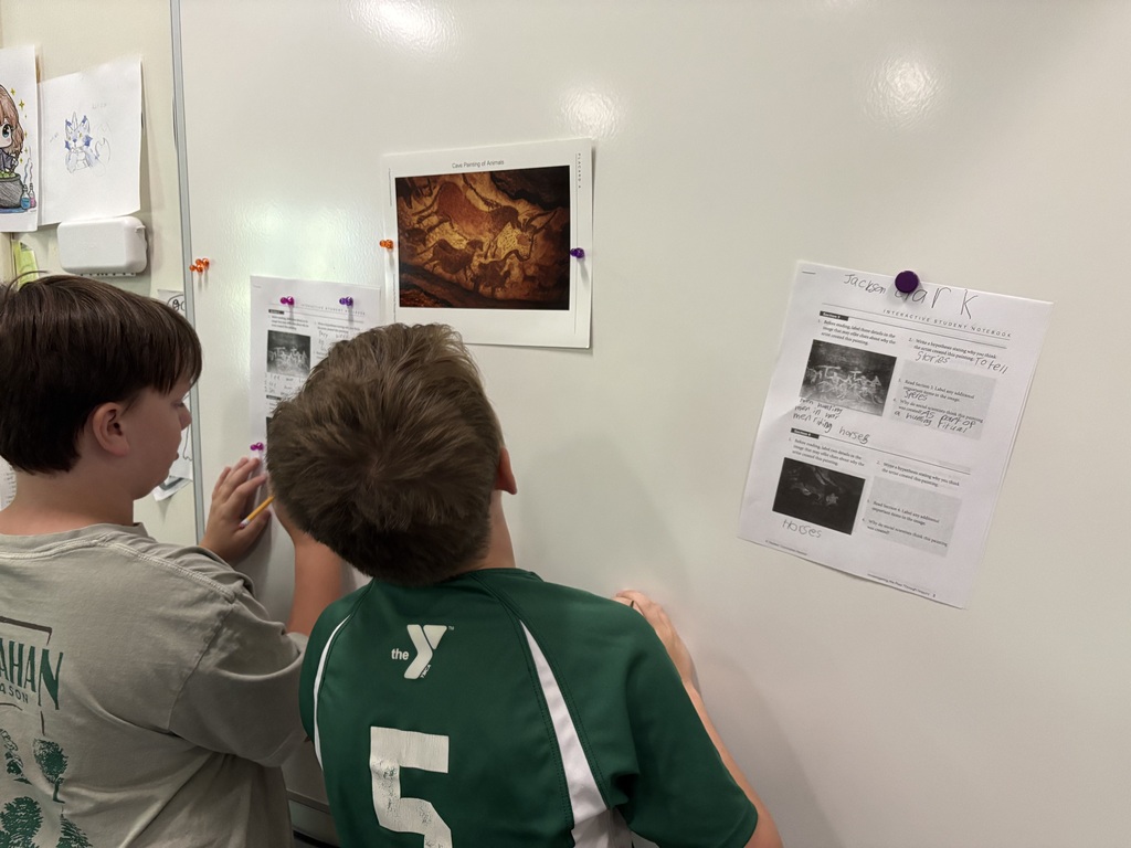 student looking at picture of cave painting