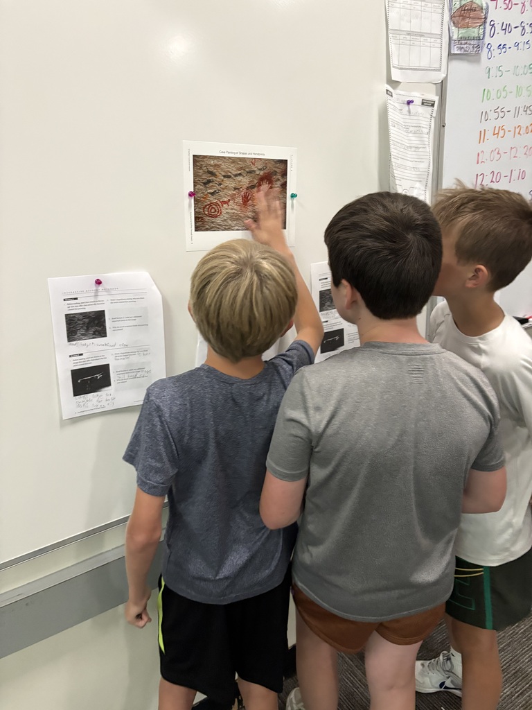 student looking at picture of cave painting