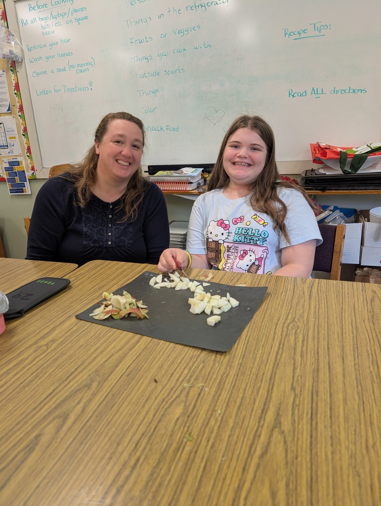 student and teacher with sliced apples in front of them