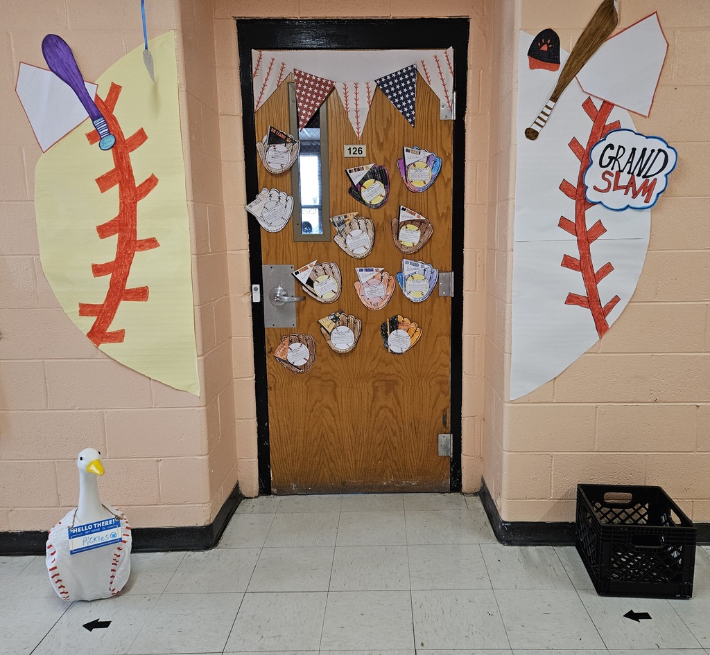 Hallway bulletin boards and classroom doors decorated with a baseball theme, featuring colorful signs, student names, and encouraging test‑taking messages such as “Cover Your Bases,” “Swing for the Fences,” and “Knock It Out of the Park” to motivate students for upcoming assessments.