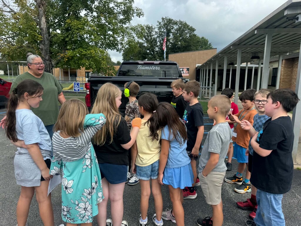 Mrs. Sims' class standing behind the truck loaded with dog and cat food.