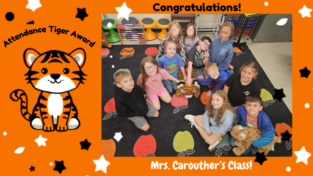 A graphic with an orange background featuring a cartoon tiger and the words “Attendance Tiger Award.” On the right side, a classroom photo shows approximately eleven elementary students gathered on a colorful rug around a plush tiger. The text “Congratulations!” appears at the top, and “Mrs. Carouther’s Class!” appears at the bottom, recognizing the class for receiving the Attendance Tiger Award.