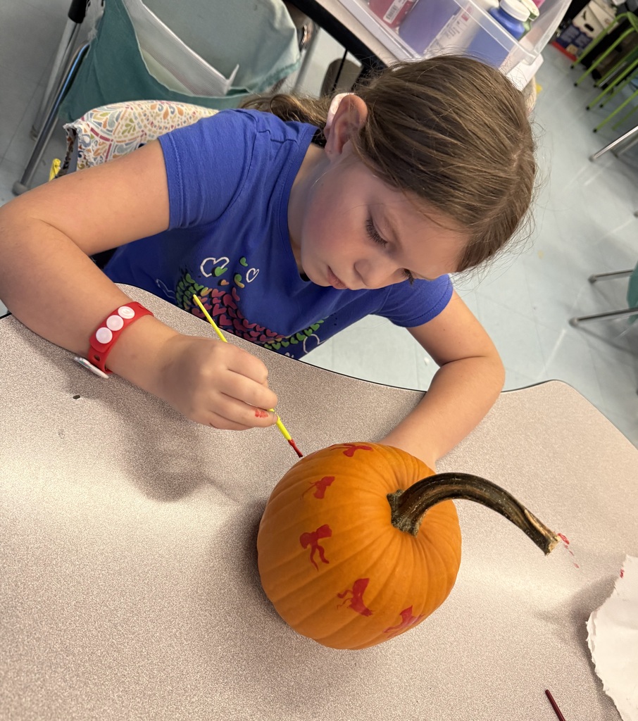 Photos show elementary students participating in a PBIS reward activity by painting pumpkins in various rooms throughout the school. Students use paint and art supplies to decorate pumpkins in different colors and designs while working at tables and classroom spaces. The pumpkins were provided by Moore’s Piggly Wiggly for students who earned enough PBIS points to participate in the fall activity.