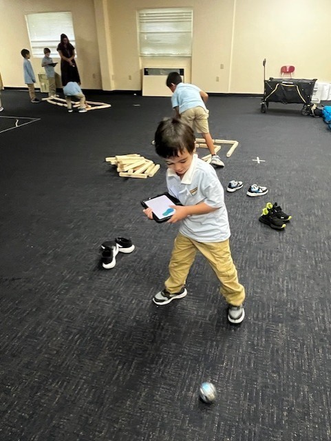 A Kindergarten Student directs his robot.