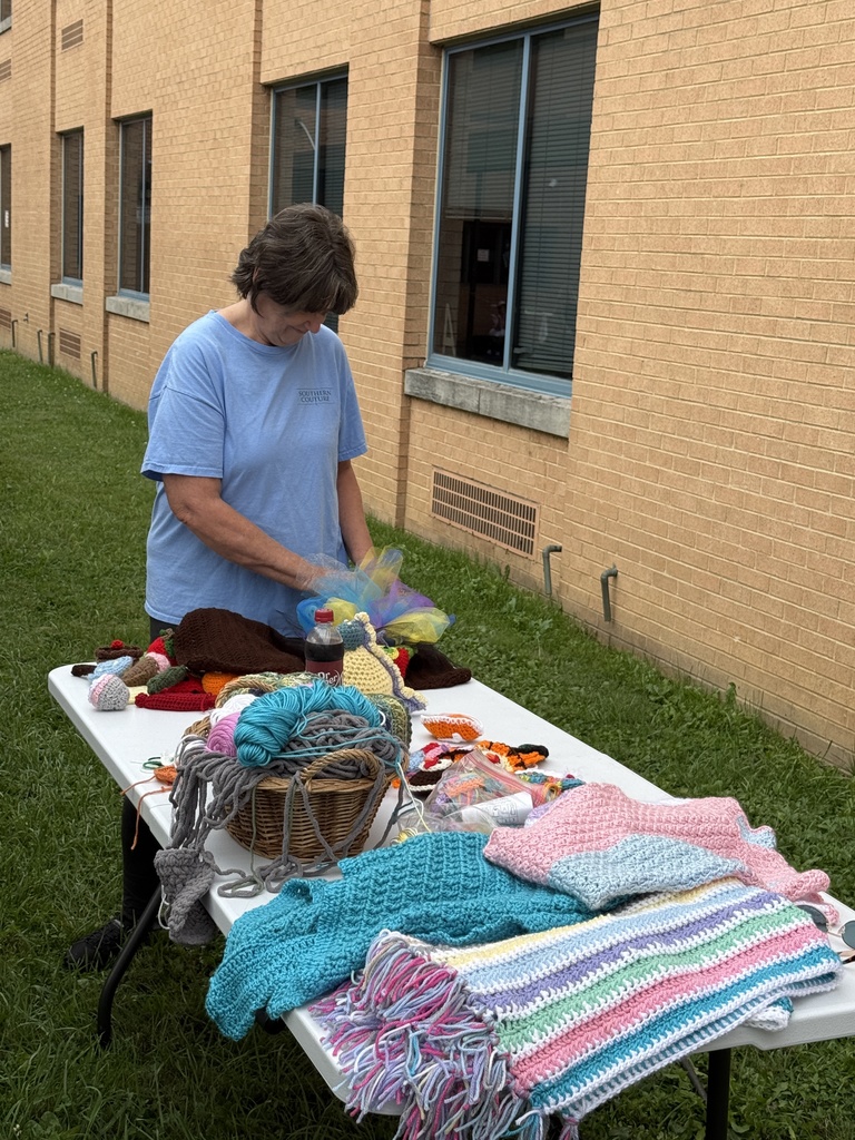 Yarn making/knitting instructor teaches students how to knit