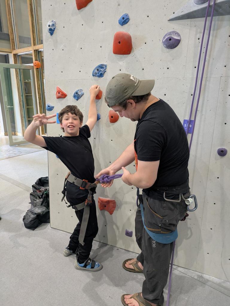 Mrs. Kay's son helps Roan get equipped to climb!
