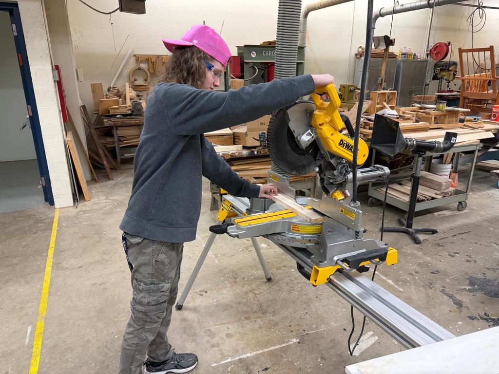 A student cuts a board