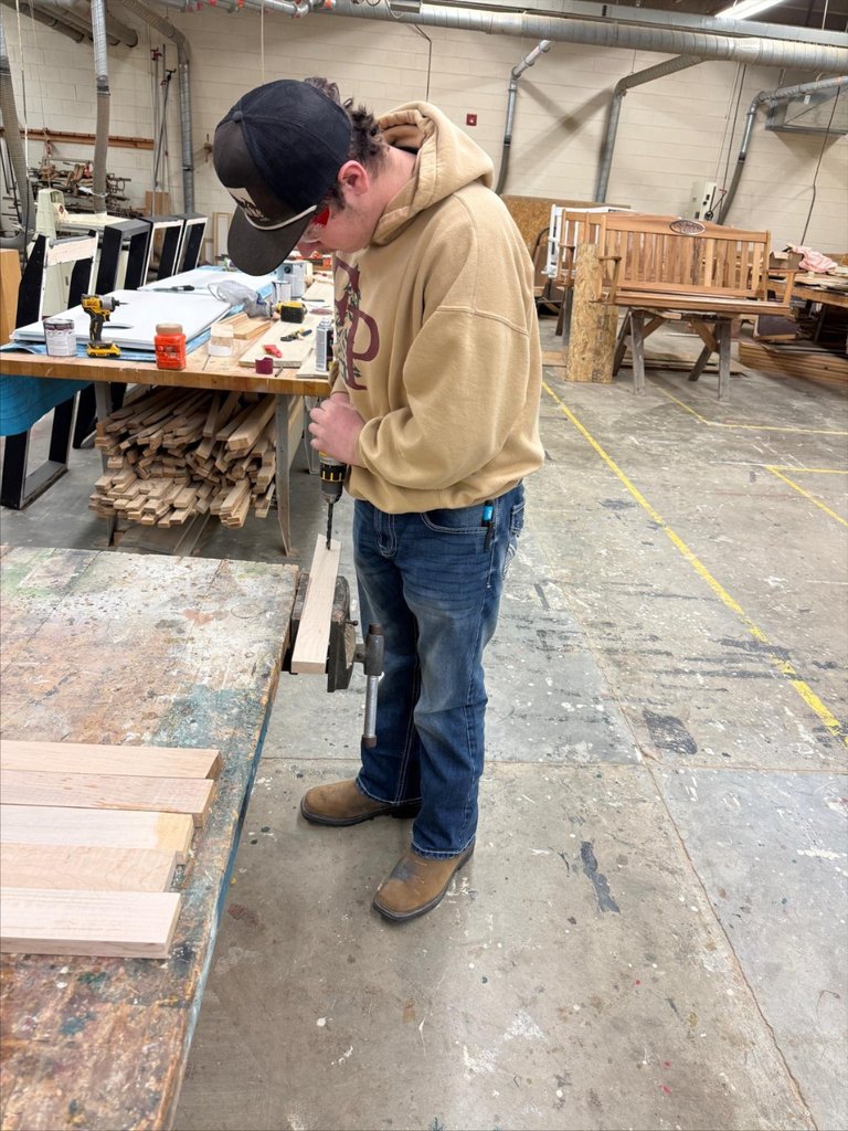 A student drills a hole