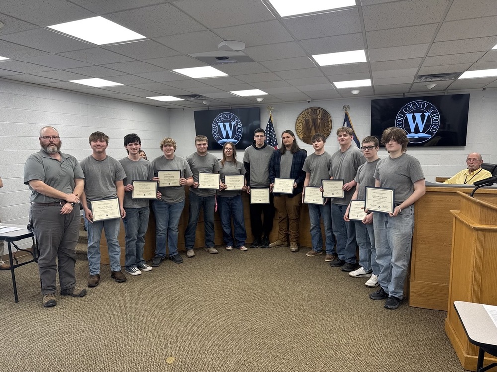 members of a student carpentry class stand and are recognized by the wood county board of education at the Bailey Board Room - students are holding certificates