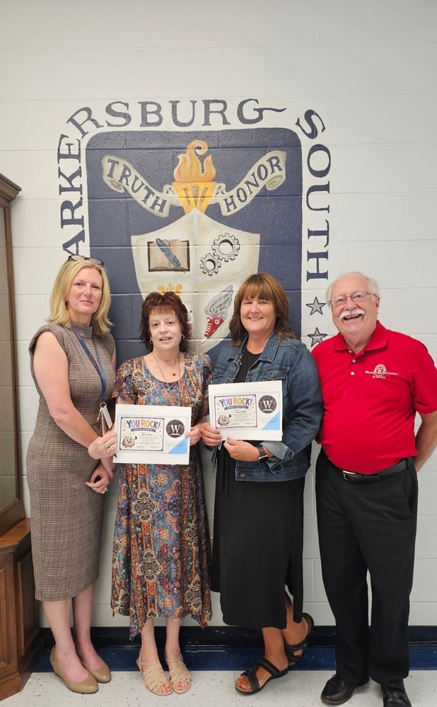 image of three women and one man posing holding certificates