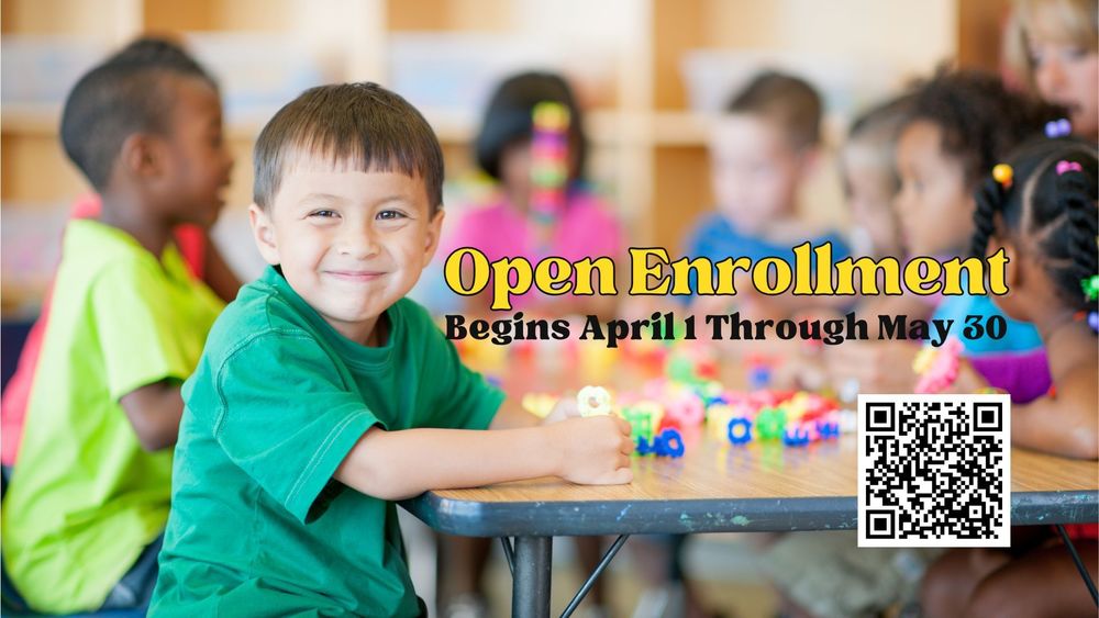 image of a smiling boy sitting at a table with fellow students who are blurred in focus