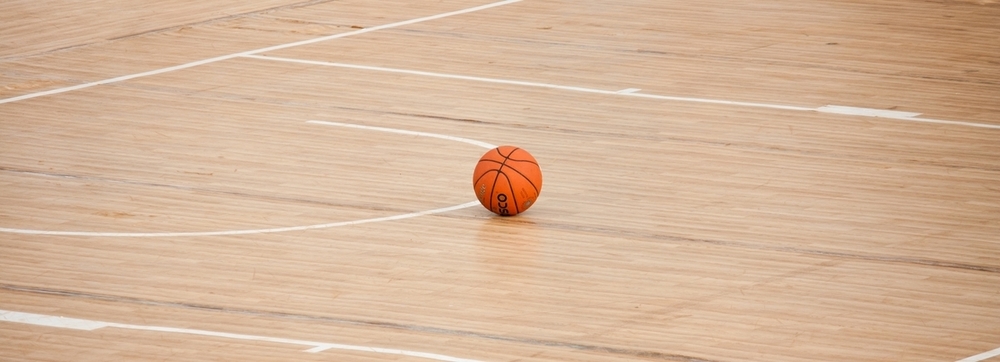 image of a basketball court and a single basketball laying in the center