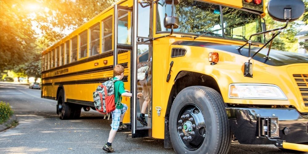 image of a school bus with two students boarding